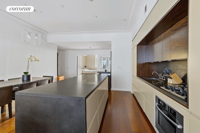 kitchen with dark countertops, modern cabinets, and stainless steel oven