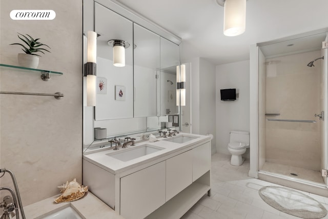 bathroom with double vanity, a sink, toilet, and a shower stall