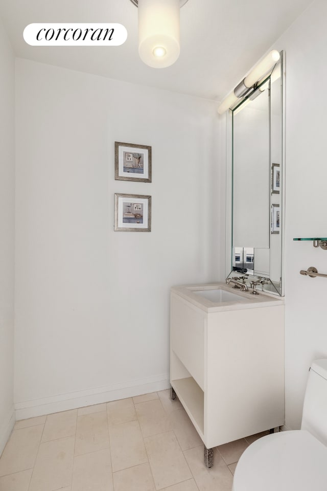 bathroom featuring baseboards, vanity, toilet, and tile patterned floors