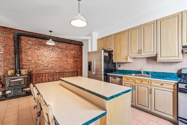 kitchen with decorative light fixtures, sink, light tile patterned floors, brick wall, and stainless steel appliances