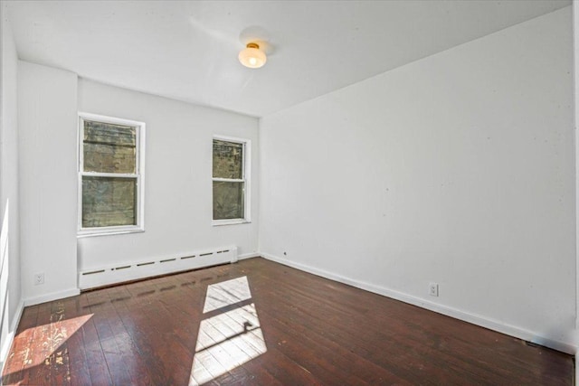 unfurnished room with dark hardwood / wood-style floors and baseboard heating