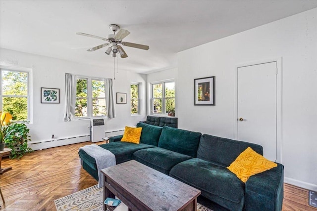 living room with baseboard heating, light parquet flooring, and ceiling fan