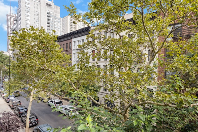 view of property with uncovered parking and a city view