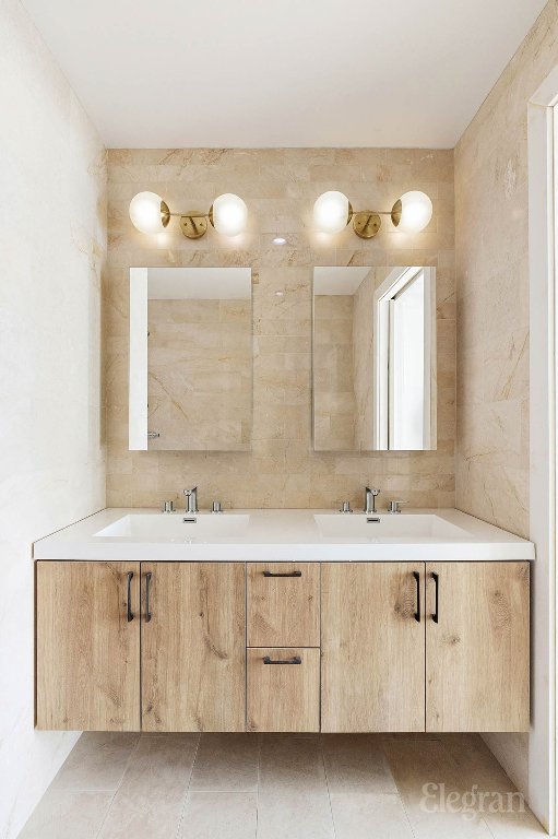 bathroom with vanity and tile walls