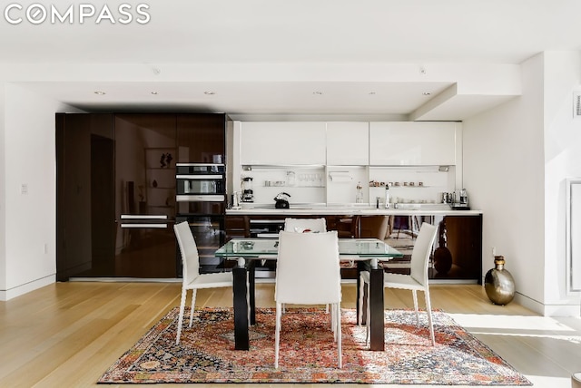 dining area with light wood-type flooring and sink