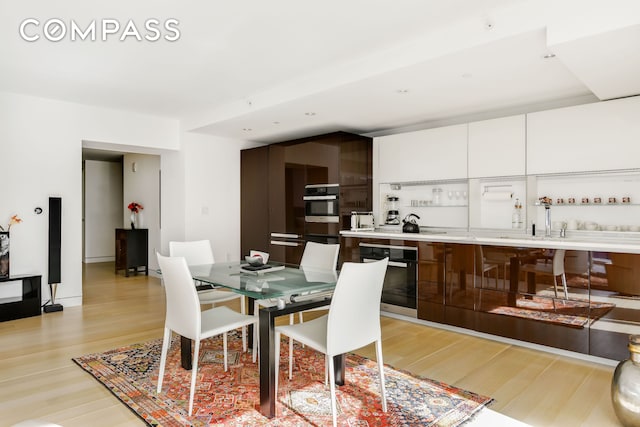 135 W 52nd St Unit 23C, New York City, NY 10019 - dining area with light wood-style flooring and bar area