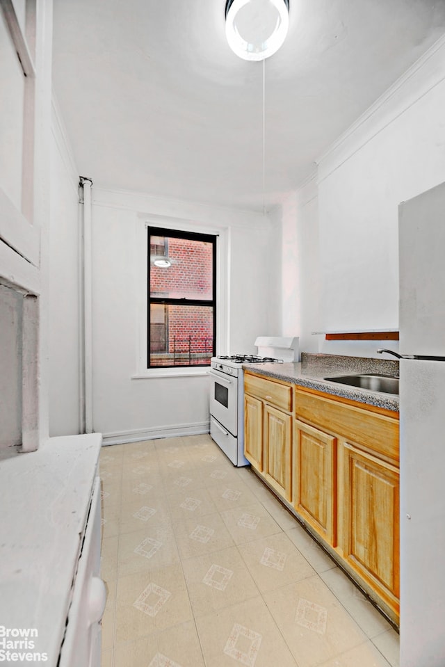 kitchen featuring ornamental molding, white appliances, a sink, and light brown cabinetry