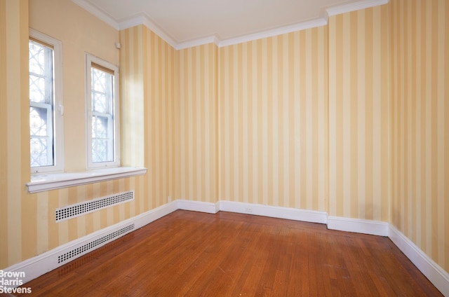 spare room featuring crown molding and hardwood / wood-style floors