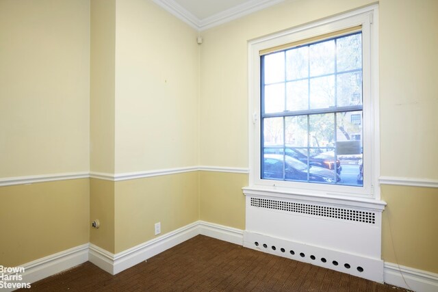 spare room featuring crown molding and hardwood / wood-style floors