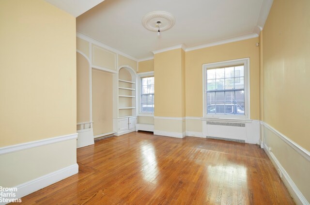 hallway with dark carpet and crown molding