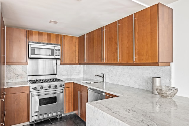 kitchen with backsplash, dark tile patterned flooring, sink, light stone countertops, and stainless steel appliances