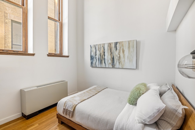 bedroom featuring wood-type flooring and radiator