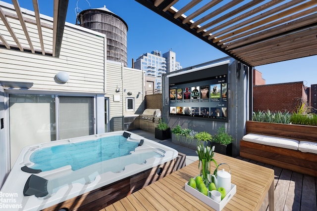 deck featuring a grill, a pergola, and exterior kitchen