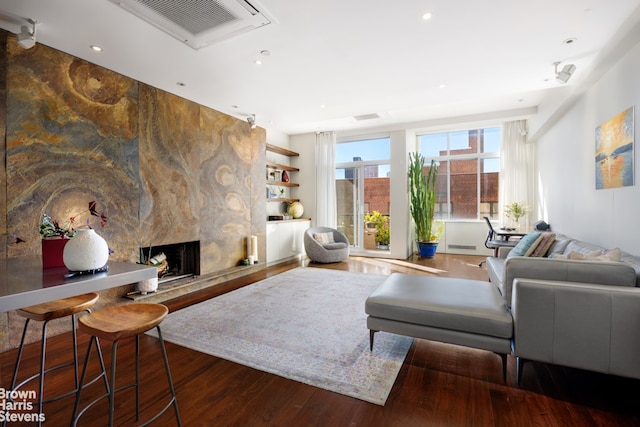 living room featuring dark wood-type flooring and a fireplace