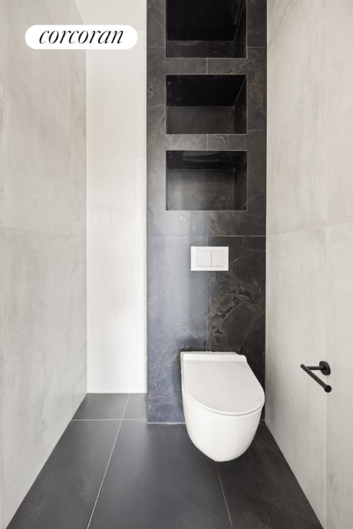 bathroom with tile walls, tile patterned floors, and toilet