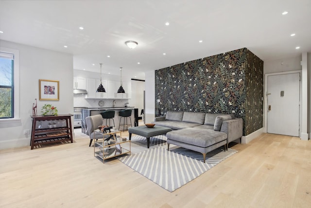 living room featuring baseboards, light wood-style flooring, and recessed lighting