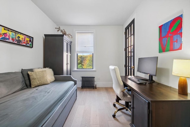 home office featuring radiator heating unit and light hardwood / wood-style floors