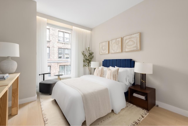 bedroom with light wood finished floors and baseboards