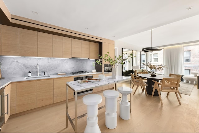 215 W 28th St Unit 12A, New York City, NY 10001 - kitchen with light brown cabinets, modern cabinets, and decorative backsplash