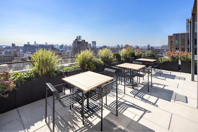 view of patio / terrace featuring a view of city and outdoor dining area