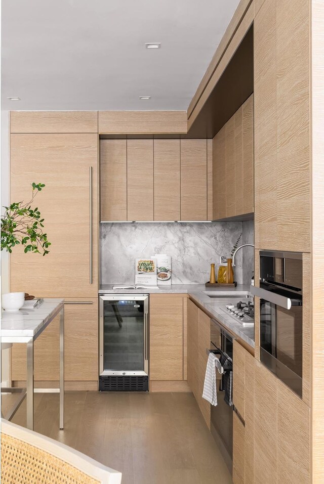 215 W 28th St Unit 12A, New York City, NY 10001 - kitchen featuring wine cooler, light brown cabinets, modern cabinets, and oven