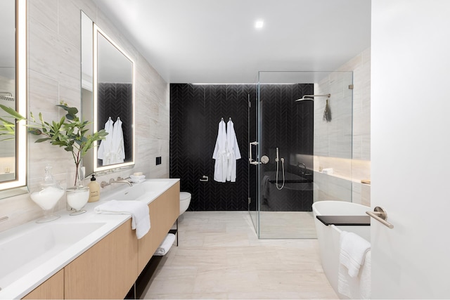 215 W 28th St Unit 12A, New York City, NY 10001 - full bathroom with tile walls, a shower stall, double vanity, and a bathtub