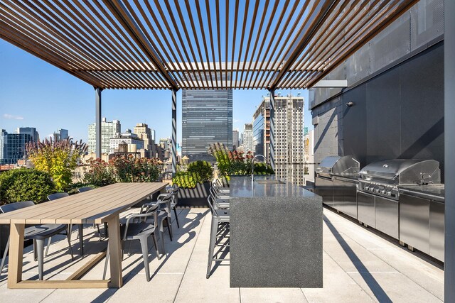 view of patio / terrace with a pergola, grilling area, exterior kitchen, a city view, and outdoor dining space