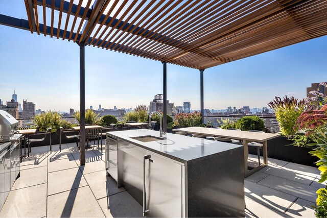 view of patio / terrace with a view of city, a pergola, outdoor dry bar, exterior kitchen, and a sink