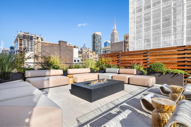 view of patio / terrace featuring an outdoor living space with a fire pit and a city view