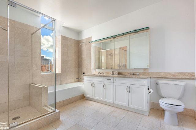 bathroom with a stall shower, a sink, toilet, and double vanity