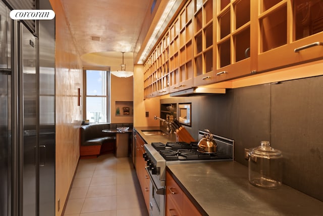 kitchen with light tile patterned floors, sink, pendant lighting, and appliances with stainless steel finishes