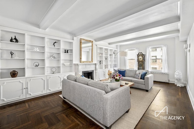 living room featuring dark parquet floors, a premium fireplace, and beamed ceiling