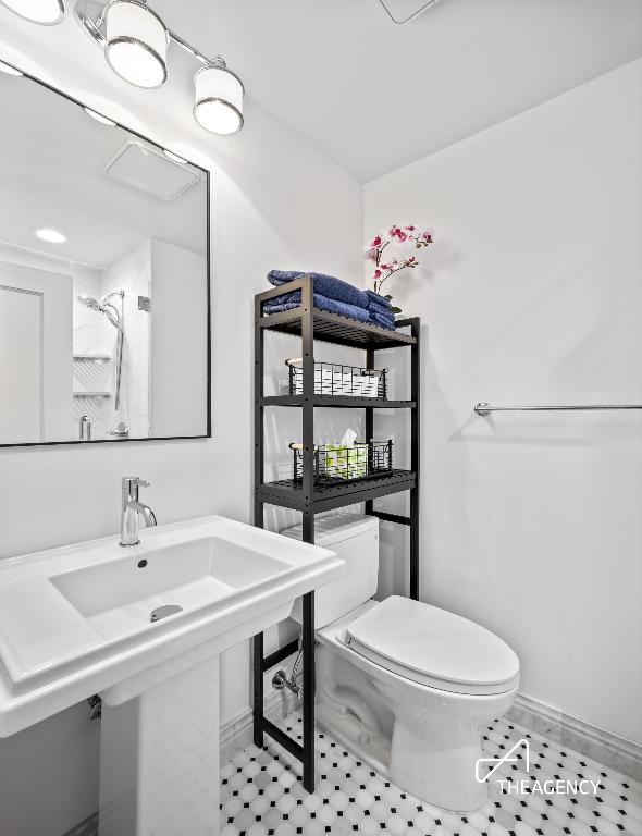 full bath with toilet, tile patterned flooring, baseboards, and a sink