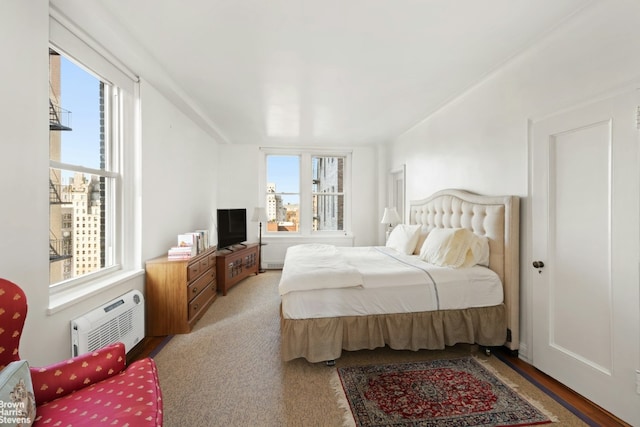 bedroom with a wall unit AC, carpet flooring, and multiple windows