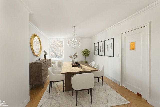 dining space featuring light parquet flooring, an inviting chandelier, and crown molding