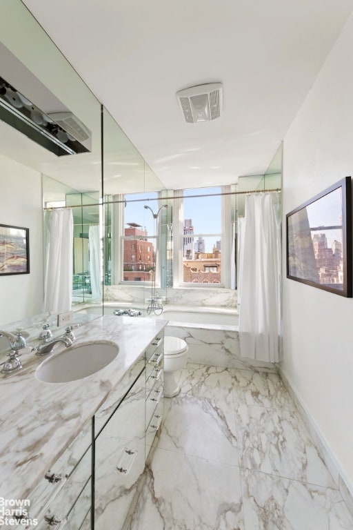 bathroom featuring toilet, vanity, and a washtub