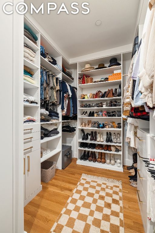 walk in closet with light hardwood / wood-style floors