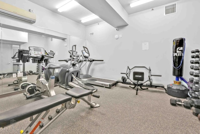 workout area featuring a wall mounted air conditioner and visible vents