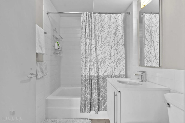 full bathroom featuring shower / bath combination with curtain, tile walls, vanity, and toilet