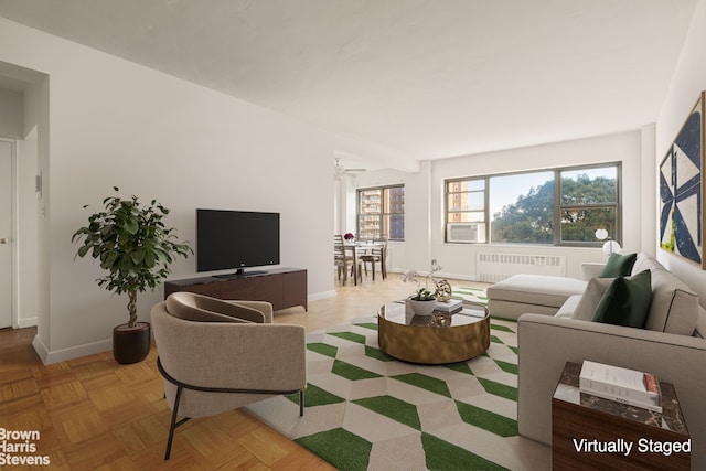 living room with a healthy amount of sunlight, radiator heating unit, baseboards, and ceiling fan