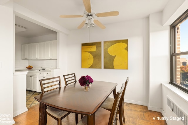 dining space with radiator, ceiling fan, and baseboards