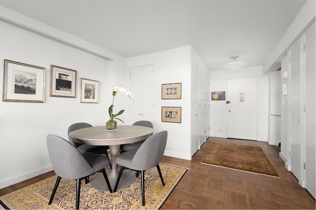 dining area featuring dark parquet floors