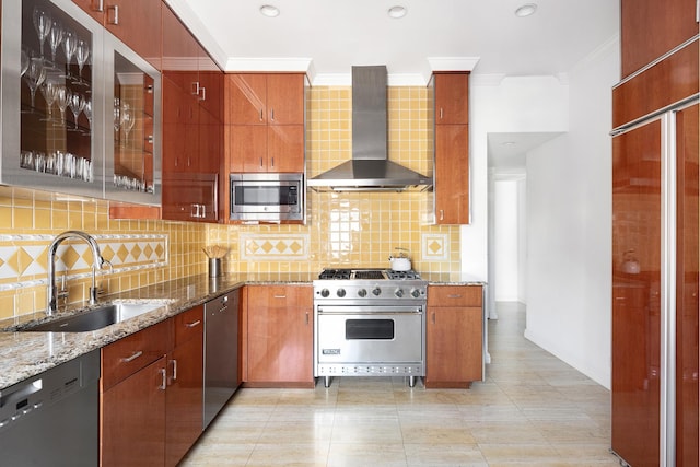 kitchen featuring wall chimney range hood, light stone countertops, ornamental molding, stainless steel appliances, and a sink