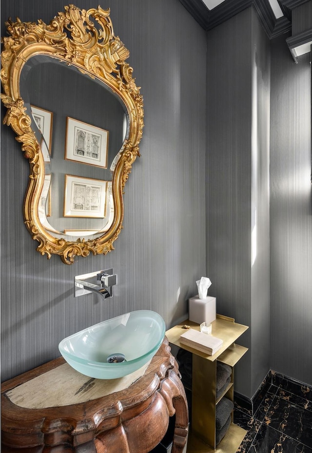 bathroom with baseboards, marble finish floor, and a sink