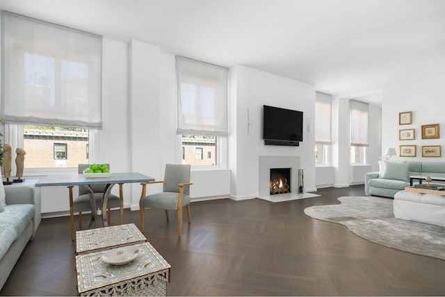 living room with a fireplace with flush hearth and baseboards