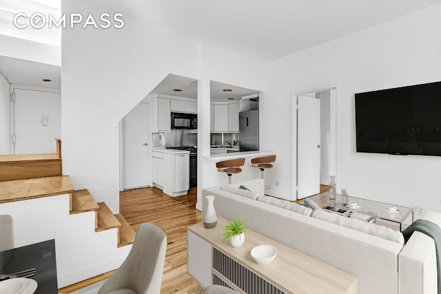 living room with stairway and light wood-type flooring