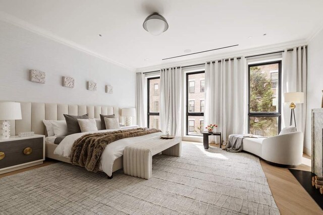 bedroom with multiple windows, light parquet flooring, and ornamental molding