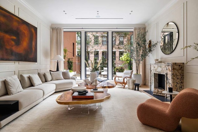 living room with crown molding, a healthy amount of sunlight, and a high end fireplace