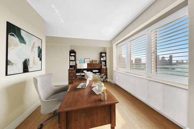 office featuring baseboards and light wood finished floors