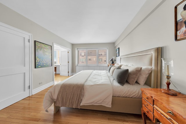 bedroom with baseboards and light wood-type flooring